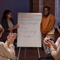clapping-hands-to-man-during-group-therapy-2025-03-18-22-20-09-utc.webp